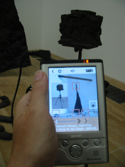 Fig. 2 The Tate Modern&rsquo;s Multimedia Tour. The visitor touches a square on the PDA screen to trigger an audio message about that aspect of the artwork on view. 